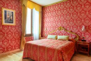 a bedroom with a bed with red wallpaper at Residenza Ca' San Marco in Venice