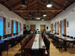 un gran salón de banquetes con mesas y sillas largas en Penzion a hostinec Na Návsi, en Nová Bystřice
