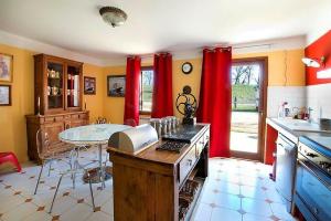 a kitchen with red drapes and a table in it at Pumperhouse Arles Camargue in Saint-Gilles