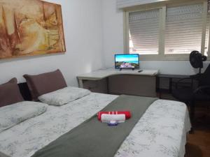 um quarto com 2 camas e um computador numa secretária em HOSTEL e POUSADA SALVADOR PRAIA em Salvador