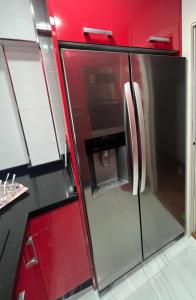 a stainless steel refrigerator in a kitchen with red cabinets at Magnífico alojamiento cerca de, Mezquita catedral in Córdoba