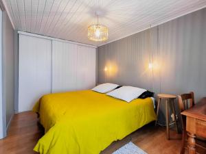 uma cama amarela num quarto com uma mesa em Sainte Marine em Sainte-Marine
