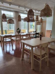 a dining room with tables and chairs and windows at EnjoyNature Resort in Lahti