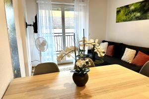 a dining room table with a vase of flowers on it at Les Naïades G29 - 2 bedrooms for 5 people ! in Avène