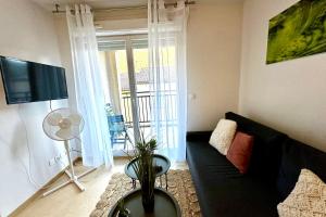 a living room with a black couch and a television at Les Naïades G29 - 2 bedrooms for 5 people ! in Avène