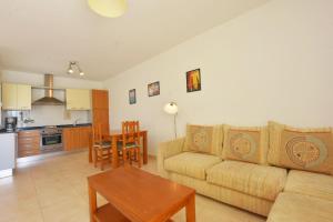 a living room with a couch and a table at Book Jet - Apartamento Tindaya Wifi & Pool in Costa Calma