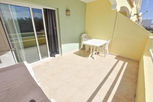 a small balcony with a table and chairs on it at Book Jet - Apartamento Tindaya Wifi & Pool in Costa Calma