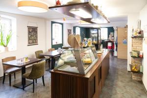 a restaurant with two tables and a counter with food at Hotel DAH-Inn in Dachau