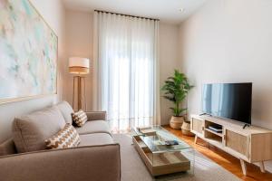 uma sala de estar com um sofá e uma televisão de ecrã plano em T83 Torneo Luminoso Apartamento Sevilla Centro em Sevilha