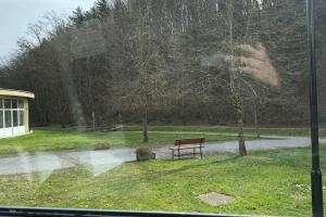a bench sitting in a park in the rain at Simba Apartment A in Smarjeske Toplice