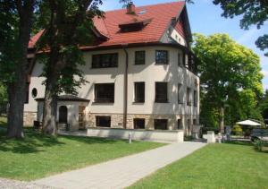 una grande casa bianca con tetto rosso di Jasny Dwór a Polanica-Zdrój