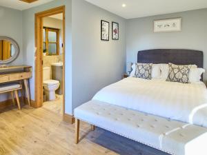 a bedroom with a bed and a sink and a bathroom at Host & Stay - Orchard Barn in Ashford