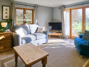 a living room with a couch and a tv at Host & Stay - Orchard Barn in Ashford +12 photos
