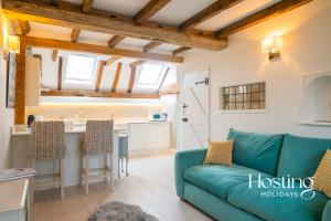 a living room with a couch and a kitchen at Stable Annex Bisham - Vibrant 1 Bed With Parking in Marlow +10 photos