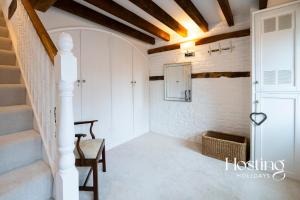 a hallway of a house with stairs and a chair at Stable Annex Bisham - Vibrant 1 Bed With Parking in Marlow