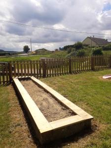 a wooden raised garden bed in front of a wooden fence at Maison de 4 chambres avec jardin clos et wifi a Villers sous Foucarmont in Villers-sous-Foucarmont