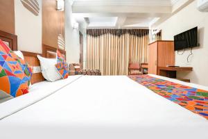 hotelshantisadan في أحمد آباد: غرفه فندقيه سرير كبير وتلفزيون