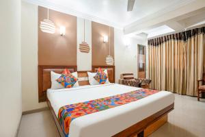 hotelshantisadan في أحمد آباد: غرفة نوم بسرير كبير في غرفة