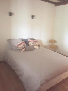 um quarto com uma grande cama branca com almofadas em Un havre de paix à la campagne près Vulcania em La Goutelle