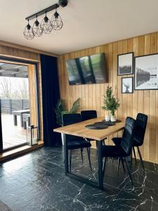 uma sala de jantar com uma mesa de madeira e cadeiras em Stodoła Na Kresach - widokowy domek drewniany, całoroczny JACUZZI & SAUNA em Bodzentyn