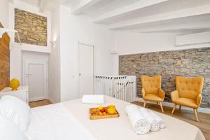 una camera bianca con un letto bianco e due sedie di Giglio a Volastra