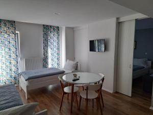 een kleine kamer met een tafel en een bed en een slaapkamer bij Villa Flower with Free Onsite Parking in Mostar