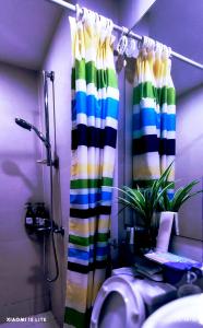 een badkamer met een douche en een kleurrijk douchegordijn bij Azure Residences Sumerton Staycation in Manilla