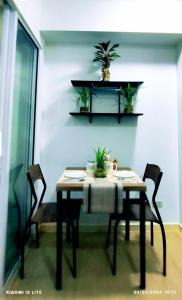 einen Esstisch mit Stühlen und Pflanzen an der Wand in der Unterkunft Azure Residences Sumerton Staycation in Manila