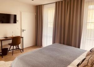 a bedroom with a bed and a desk and a window at De Molenhoeve B&B in Voeren