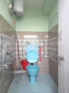 a bathroom with a blue toilet in a stall at Diksha Homestay in Darjeeling
