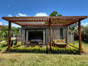 a pergola with chairs and a table in a yard at LalaGalu - Beachfront EcoCabins in Diani Beach