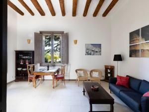 ein Wohnzimmer mit einem blauen Sofa und einem Tisch in der Unterkunft Chapel Apartment with Private Terrace in La Torre de Claramunt