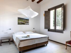 ein Schlafzimmer mit einem Bett mit einem Kronleuchter darüber in der Unterkunft Chapel Apartment with Private Terrace in La Torre de Claramunt