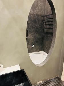 a bathroom with a round mirror on the wall at Hostel Boutique in Milan