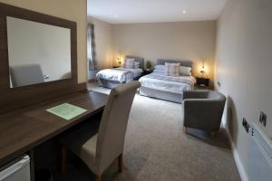 a room with two beds and a desk with a mirror at Bannview Bed & Breakfast in Portadown