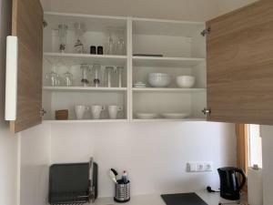 a kitchen with white shelves with glass items on it at Holiday apartment Leiner 2 in Garmisch-Partenkirchen