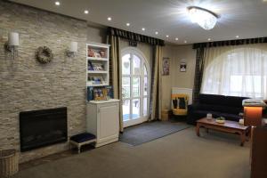 a living room with a fireplace and a couch at Zenit Panzió in Miskolctapolca