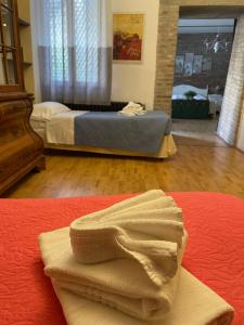 a room with two beds and a towel on a bed at Stella De' Tolomei in Ferrara