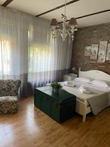 um quarto com uma cama, um sofá e um lustre em Stella De' Tolomei em Ferrara
