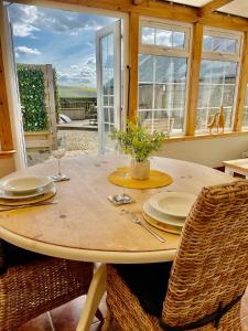 een houten tafel met 2 stoelen en een tafel met glazen bij The Bothy in Kelso