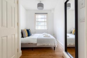 a bedroom with a bed and a mirror at The Haggerston Collection in London