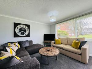 a living room with a couch and a table at Modern & secluded home in Frenchay in Bristol