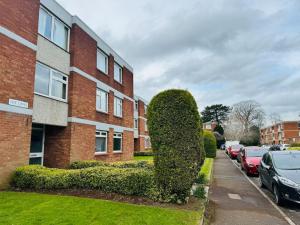 a large bush in front of a brick building at Modern & secluded home in Frenchay in Bristol