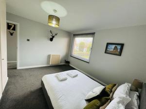 um quarto com uma cama branca e uma janela em Modern & secluded home in Frenchay em Bristol