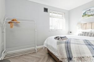una camera bianca con un letto e una finestra di Spacious 3 Bedroom Modern House with Garden a Kent