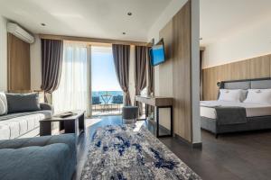 um quarto de hotel com uma cama e um sofá em Continental Hotel em Ulcinj