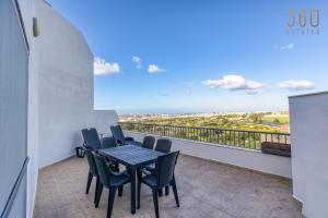 una mesa y sillas en un balcón con vistas en Beautiful PENT with terrace & spectacular views by 360 Estates, en Luqa