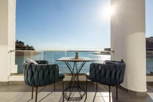 een tafel en 2 stoelen in een kamer met een raam bij Continental Hotel in Ulcinj