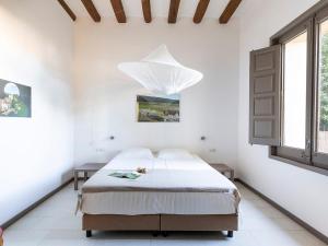 1 dormitorio con 1 cama con lámpara de araña encima en Winery apartment for two with private terrace, en La Torre de Claramunt
