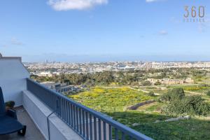 a balcony with a view of a city at Beautiful PENT with terrace & spectacular views by 360 Estates in Luqa